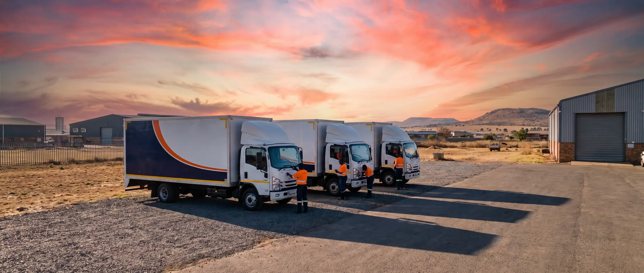 Three Just In Time Removals trucks lined up at the depot at sunrise